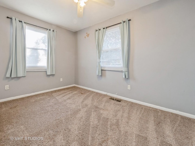 carpeted spare room with plenty of natural light and ceiling fan