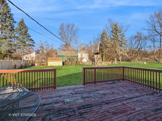 deck featuring a yard, a playground, and a storage unit