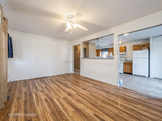 unfurnished living room with ceiling fan and hardwood / wood-style floors