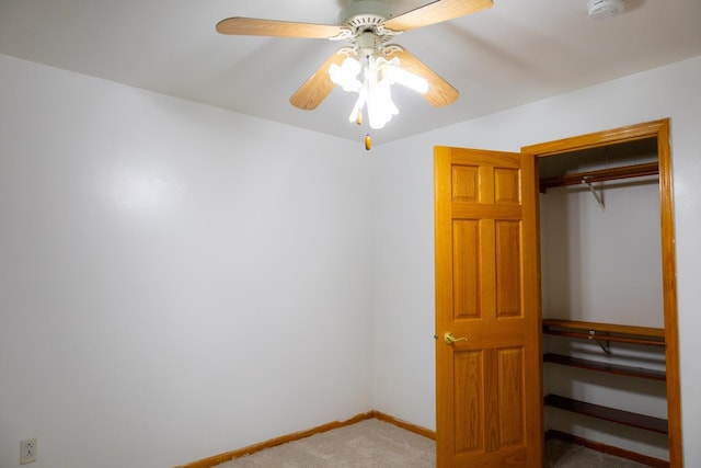 unfurnished bedroom with carpet, a closet, and ceiling fan