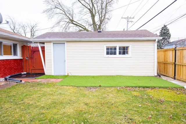 back of property with a yard and an outdoor structure