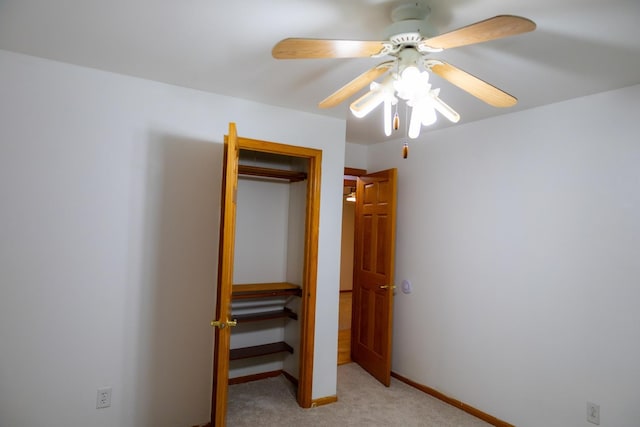 unfurnished bedroom featuring ceiling fan, a closet, and light colored carpet