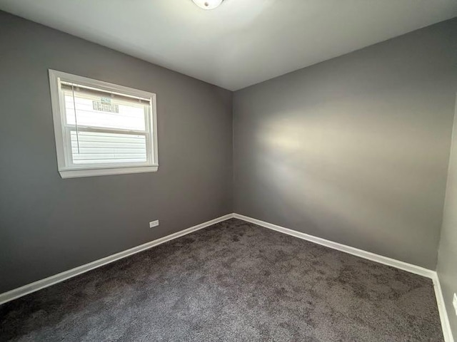 spare room with dark colored carpet