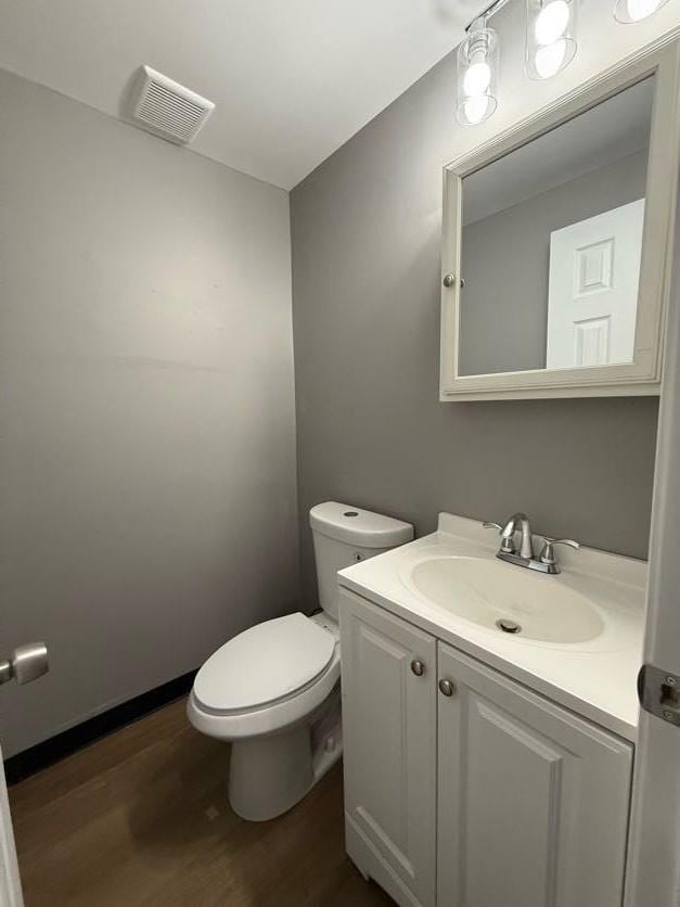 bathroom featuring toilet, vanity, and hardwood / wood-style flooring