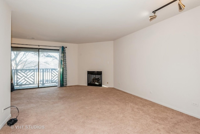 unfurnished living room with light carpet and rail lighting