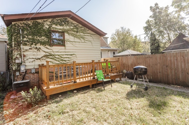 rear view of house with a yard, a deck, and central AC unit