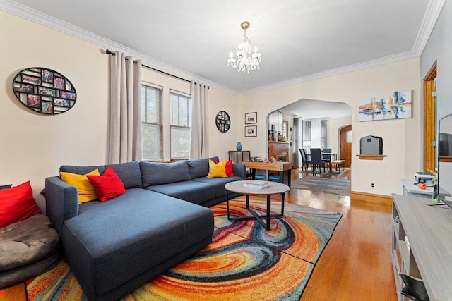 living room featuring light hardwood / wood-style flooring, a notable chandelier, and crown molding