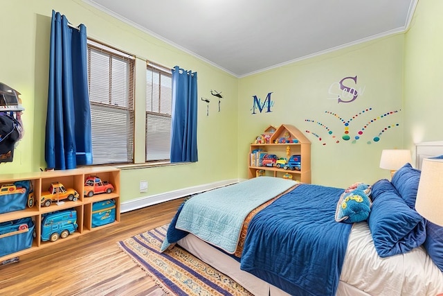 bedroom with a baseboard radiator, hardwood / wood-style flooring, and ornamental molding