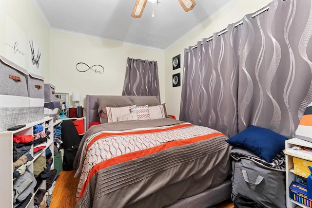 bedroom featuring ceiling fan, wood-type flooring, and ornamental molding