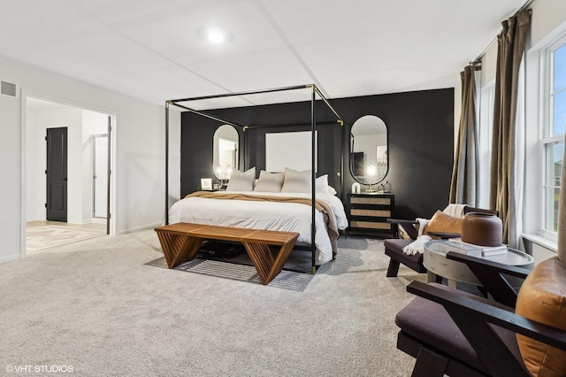 bedroom featuring light carpet and multiple windows