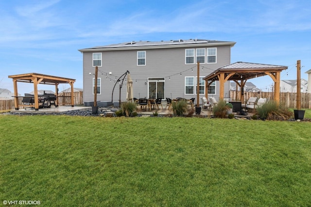 back of property featuring a gazebo, a yard, and a patio