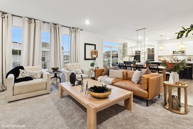 living room with light carpet and a notable chandelier