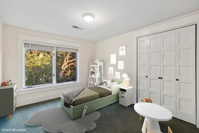 bedroom featuring a closet and dark colored carpet