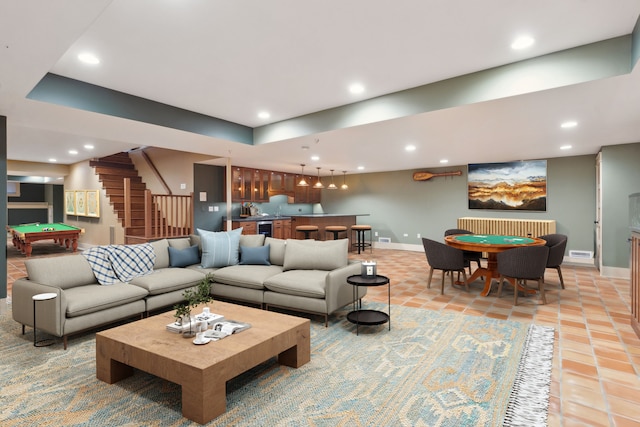 living room featuring bar area, radiator, pool table, and light tile patterned flooring