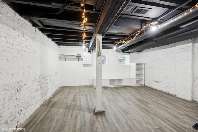 basement with hardwood / wood-style floors and electric panel