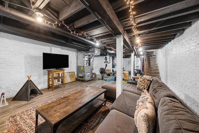 basement with hardwood / wood-style floors, track lighting, and heating unit