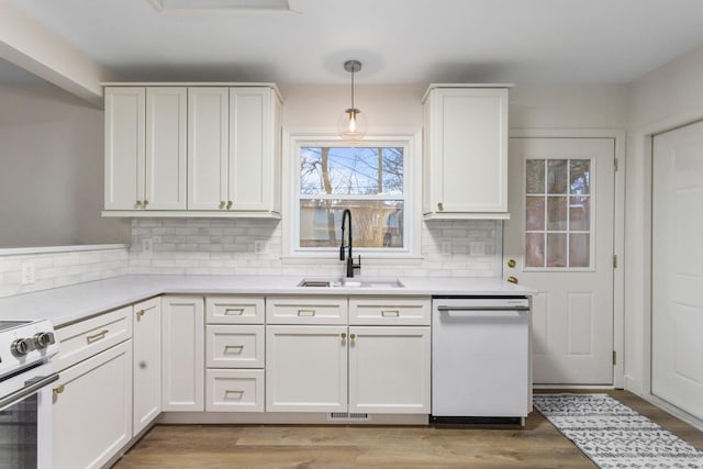 kitchen with pendant lighting, sink, white appliances, and white cabinets