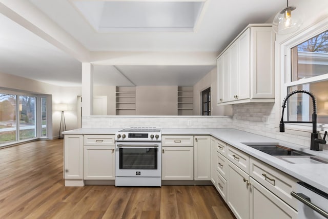 kitchen with white cabinets, white electric range, decorative light fixtures, sink, and kitchen peninsula