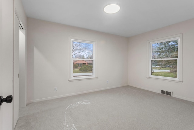 unfurnished room featuring light carpet