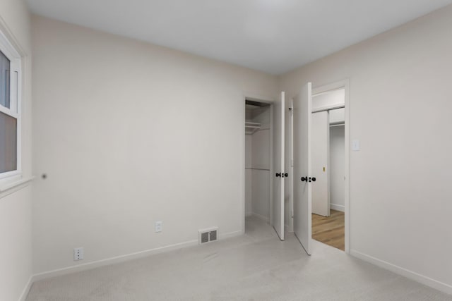 unfurnished bedroom featuring light carpet