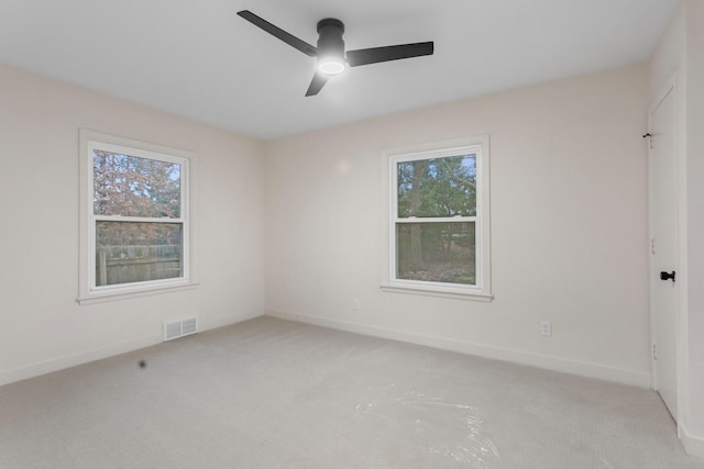 empty room featuring ceiling fan and light carpet