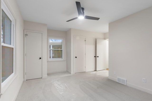 unfurnished bedroom featuring light carpet and ceiling fan