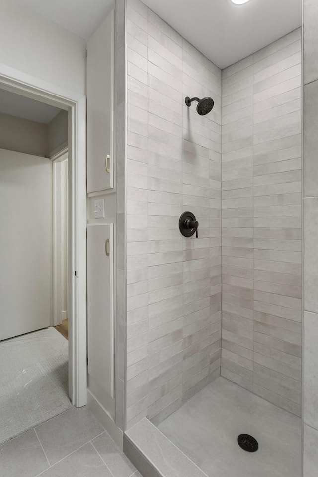 bathroom featuring a tile shower and tile patterned flooring