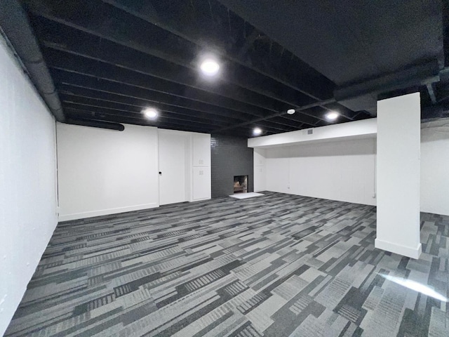 basement featuring dark colored carpet