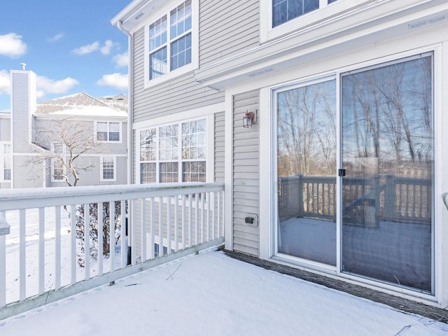 view of snow covered back of property