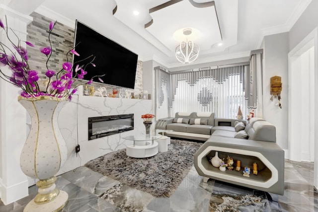 living room with crown molding, a premium fireplace, and an inviting chandelier