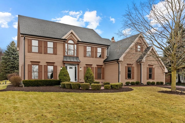 colonial inspired home featuring a front lawn