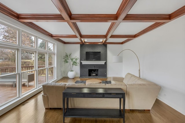 living room featuring dark hardwood / wood-style floors, a fireplace, ornamental molding, coffered ceiling, and beam ceiling