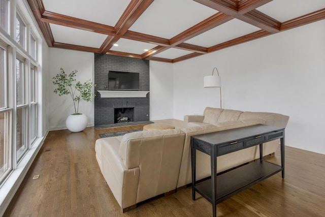 living room with coffered ceiling, a fireplace, and wood-type flooring