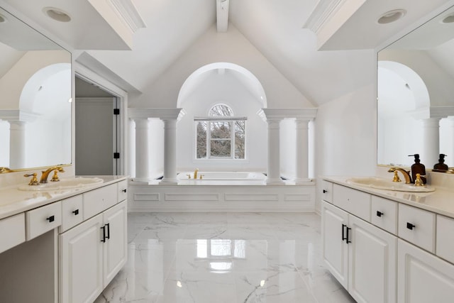 bathroom featuring vanity, lofted ceiling with beams, decorative columns, and a washtub