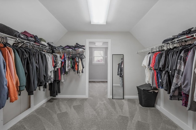 walk in closet with vaulted ceiling and carpet