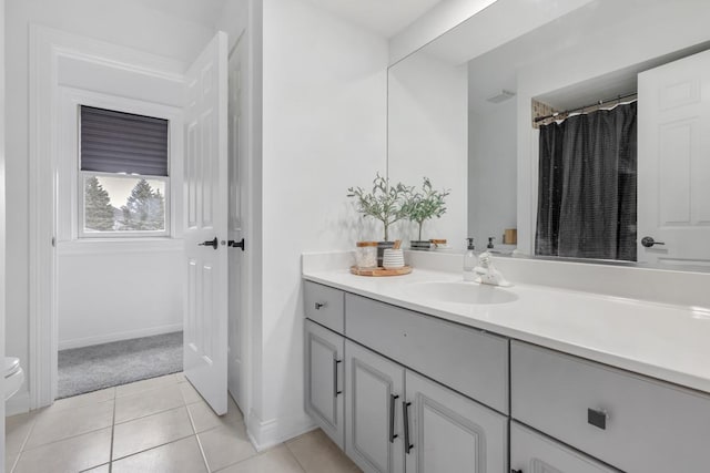 bathroom with tile patterned flooring, vanity, and walk in shower