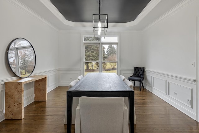 dining room with dark hardwood / wood-style flooring, ornamental molding, and a raised ceiling