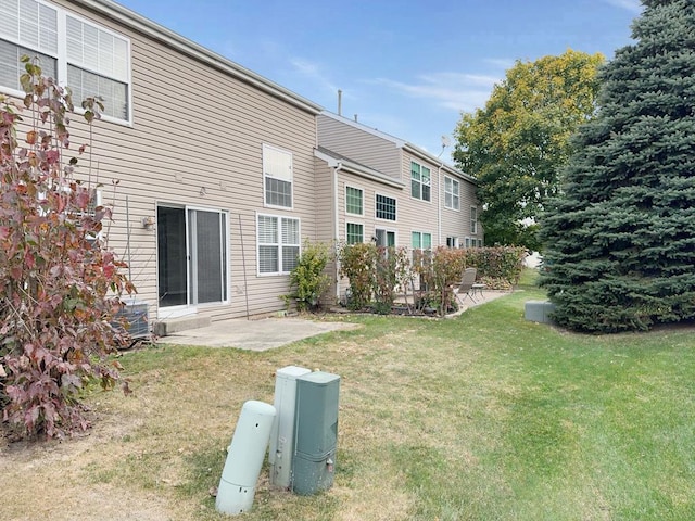 rear view of property with a lawn and a patio area