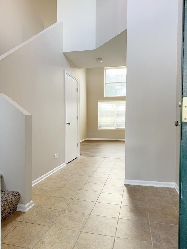 interior space featuring light tile patterned floors and a towering ceiling