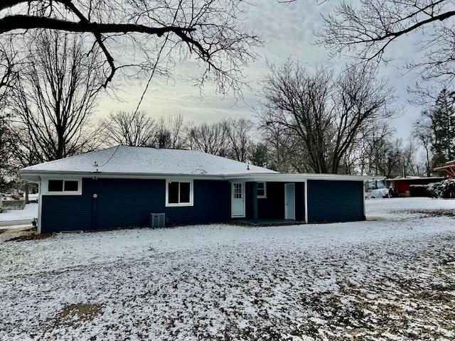 snow covered property featuring central AC