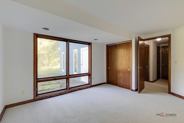 unfurnished bedroom featuring light carpet