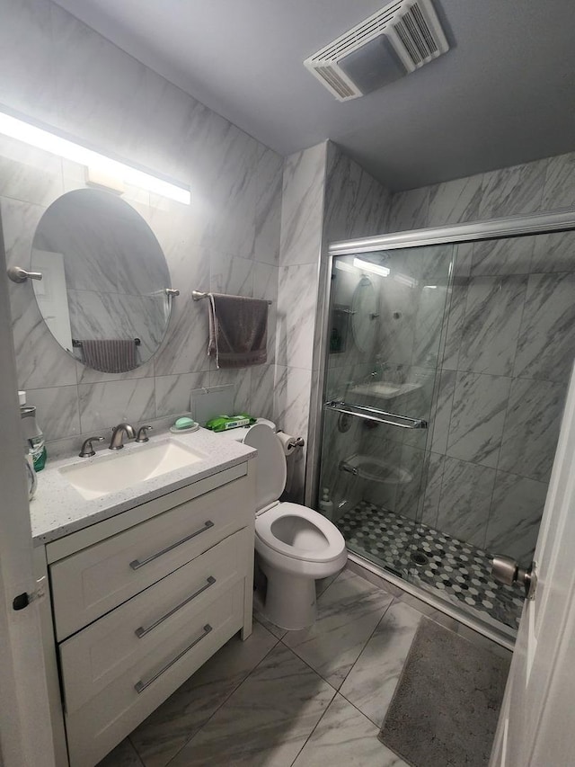 bathroom with vanity, toilet, walk in shower, and tile walls