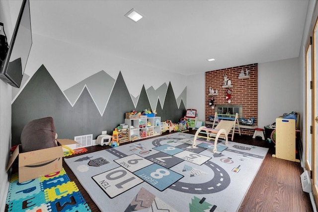 game room featuring a fireplace and dark hardwood / wood-style floors