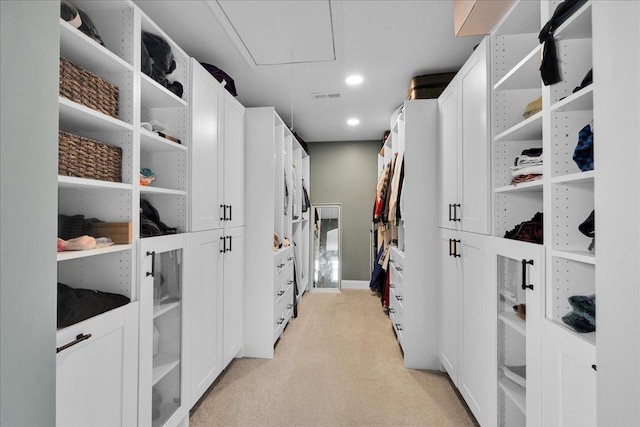 walk in closet featuring light carpet