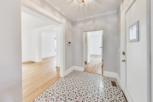 hall featuring baseboards and wood finished floors