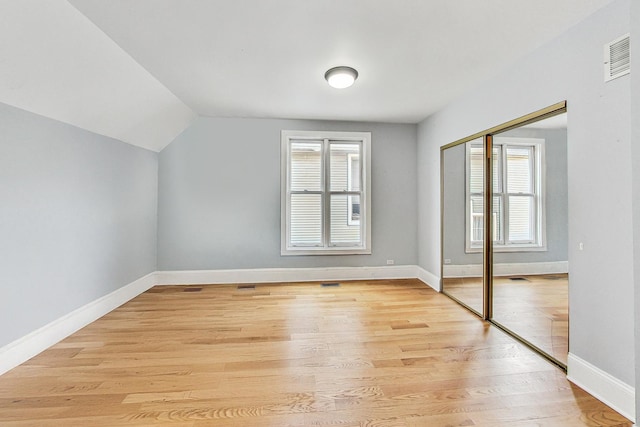 bonus room with lofted ceiling, light wood-style floors, visible vents, and baseboards