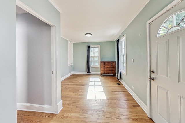 entrance foyer featuring crown molding, light wood-type flooring, and baseboards