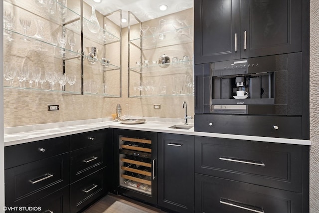 bar with wine cooler, indoor wet bar, and a sink