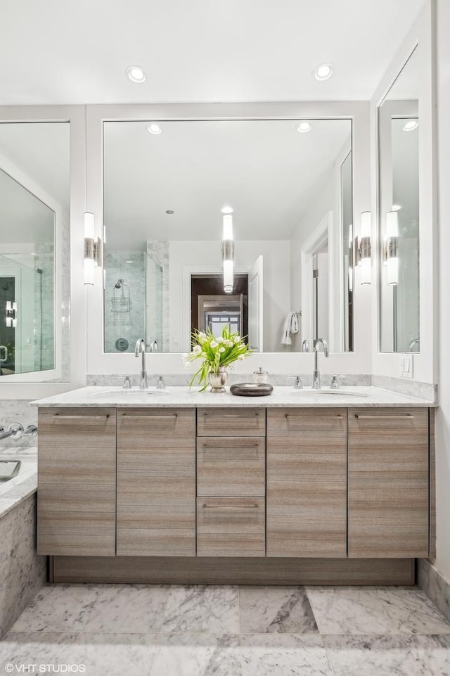 bathroom featuring double vanity, a stall shower, a sink, and recessed lighting