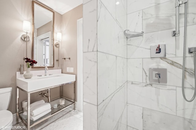 full bathroom featuring a sink, a marble finish shower, and toilet